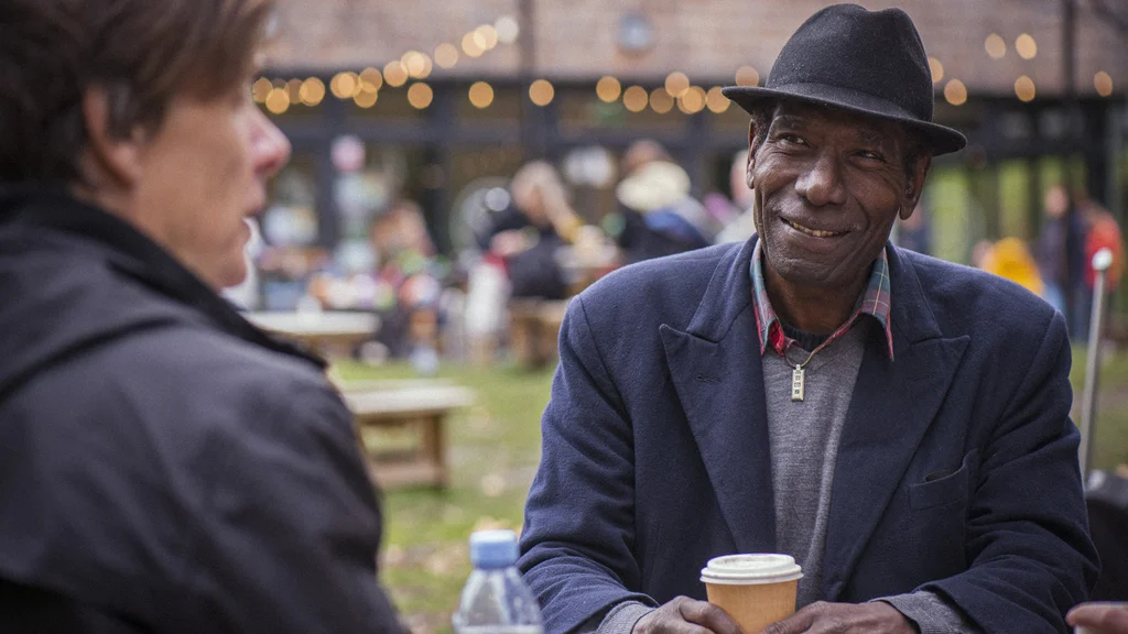 Older people socialising outside with coffee