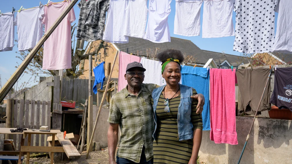 Older man with his family member hanging out washing outside